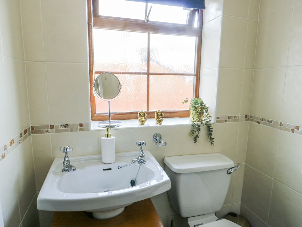 A bathroom with a sink and toilet at Smithy Cottage in Cemaes Bay