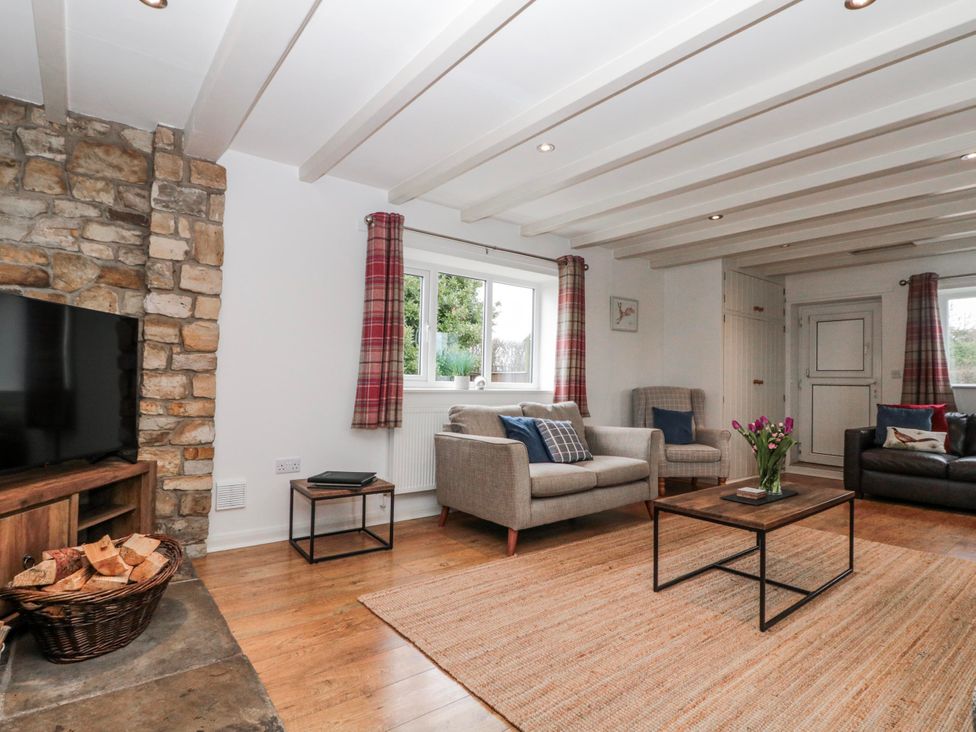 A living room with a television and coffee table at Wold Cottage in Hunmanby