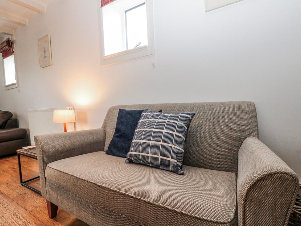 A living room with a sofa and lamp at Wold Cottage in Hunmanby