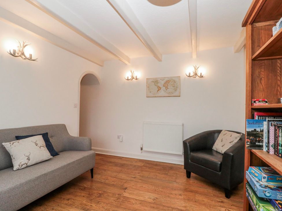 A living room with a sofa and armchair at Wold Cottage in Hunmanby