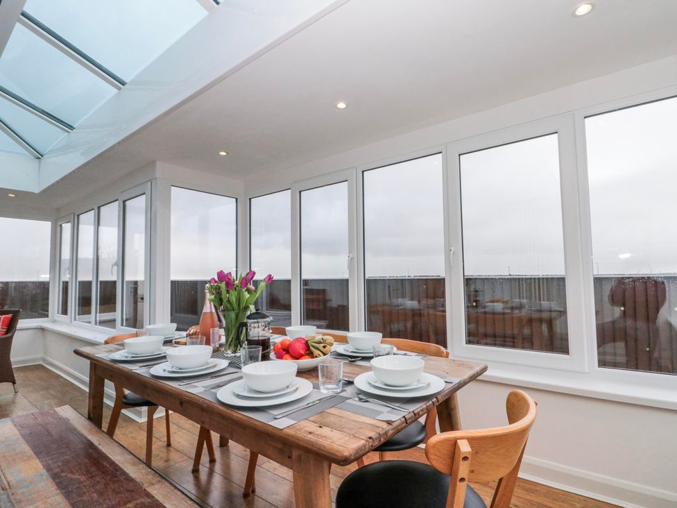 A dining table set with dishes and flowers at Wold Cottage in Hunmanby