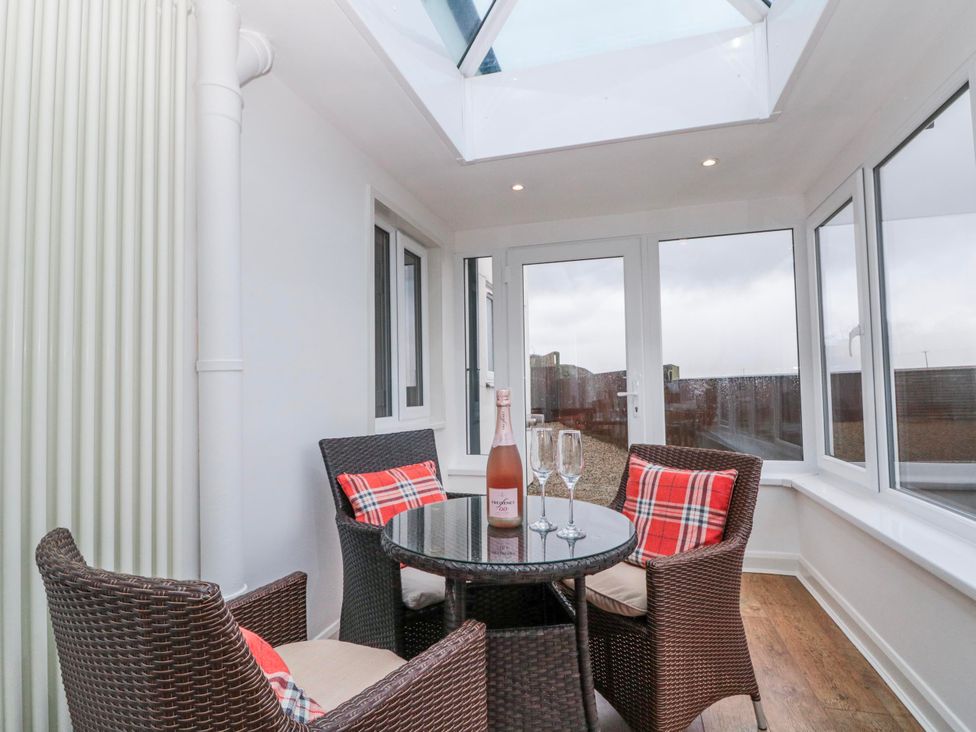 A conservatory with a table and chairs at Wold Cottage in Hunmanby