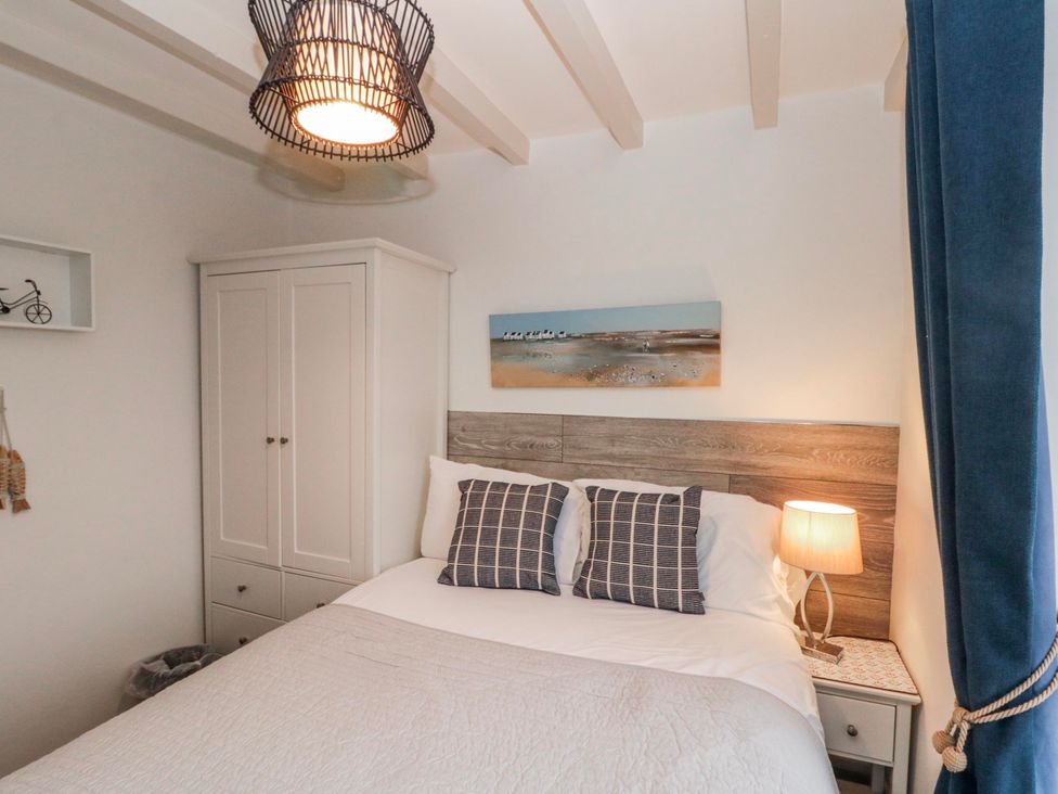 A bedroom with a bed and wardrobe at Wold Cottage in Hunmanby