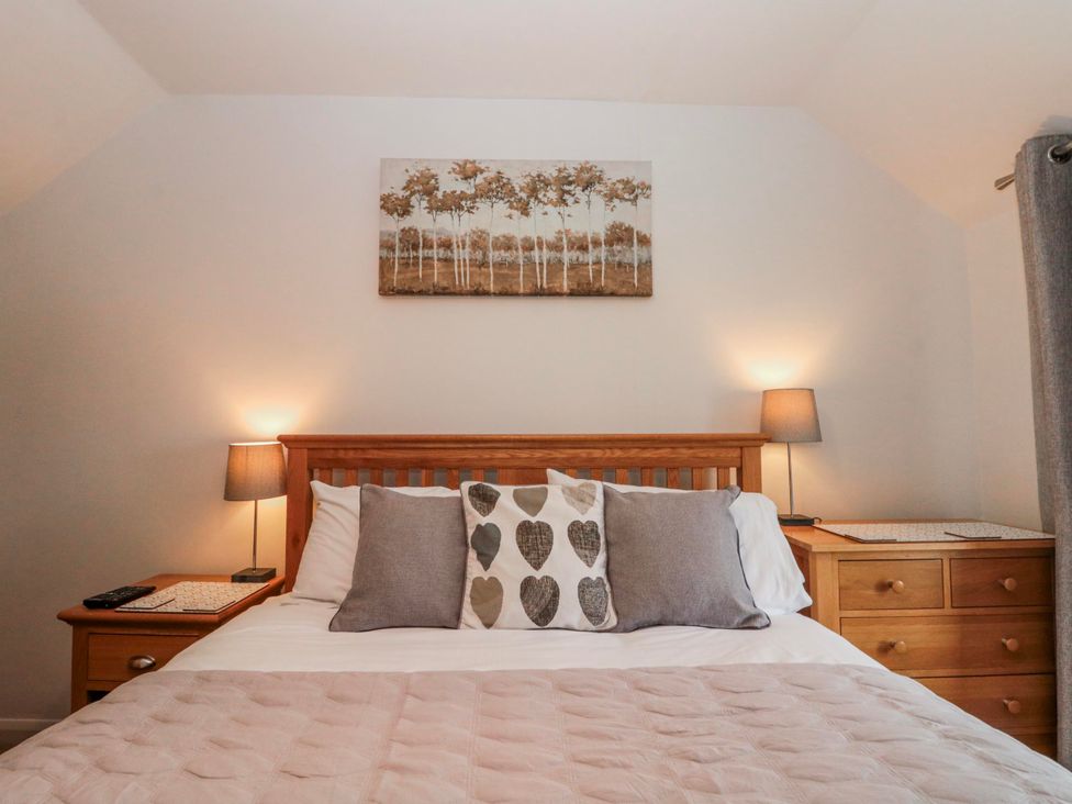 A bedroom with a bed and decorative pillows at Wold Cottage in Hunmanby