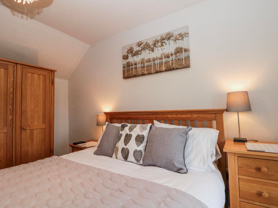 A bedroom with a bed and wardrobe at Wold Cottage in Hunmanby