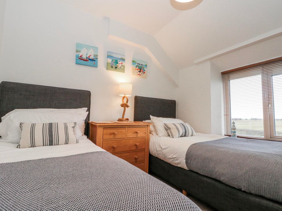 A bedroom with two beds and a nightstand at Wold Cottage in Hunmanby