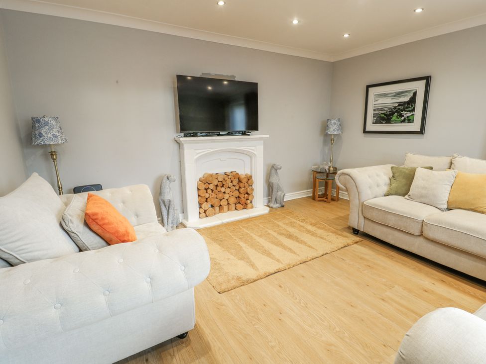 A living room with a television and a rug at 1 The Old Smithy in Cemaes Bay