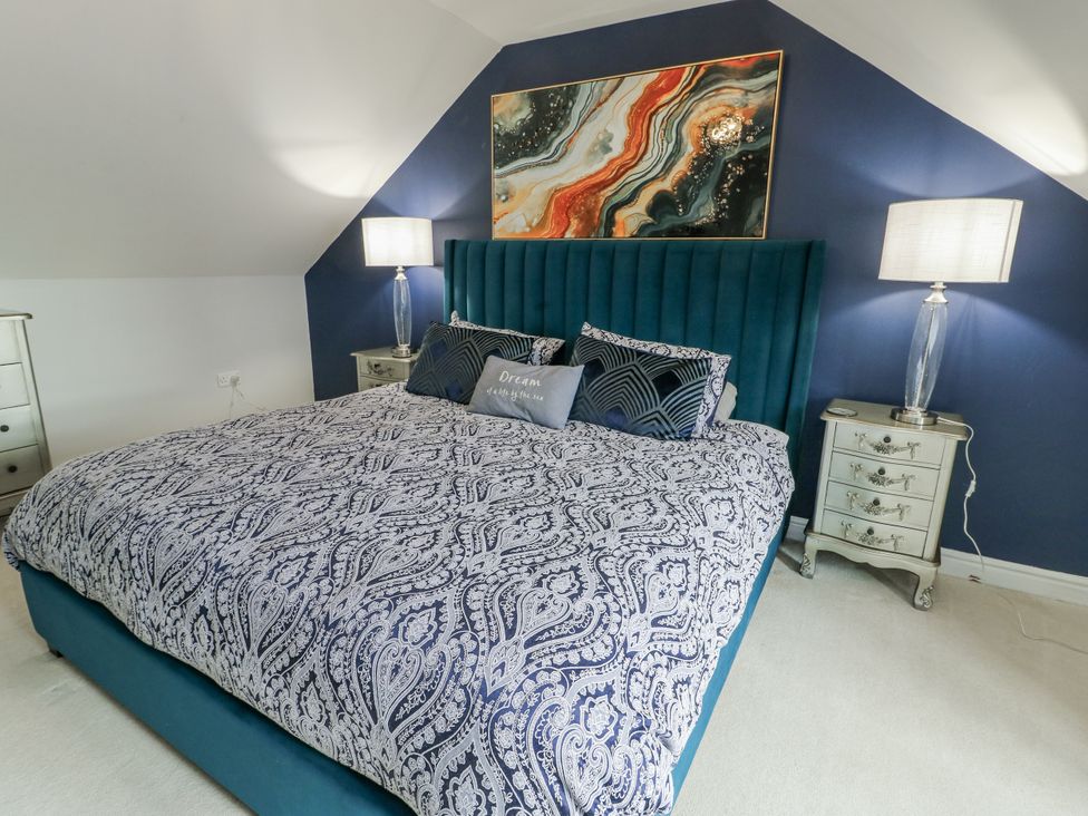 A bedroom with a bed and bedside tables at 1 The Old Smithy Cemaes Bay