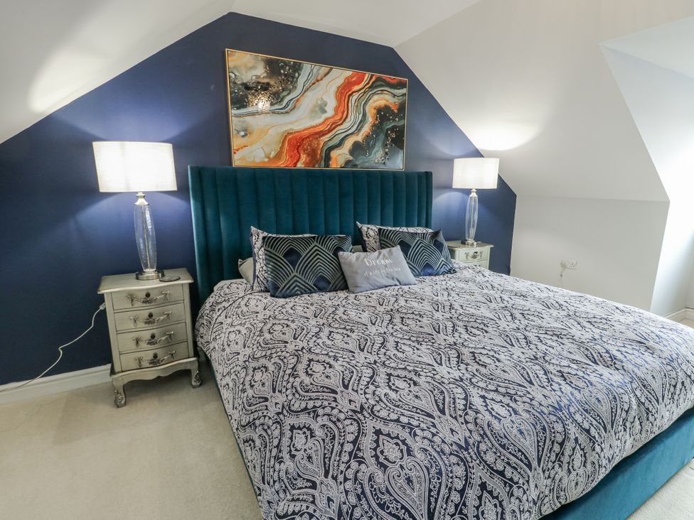 A bedroom with a bed and bedside tables at 1 The Old Smithy in Cemaes Bay