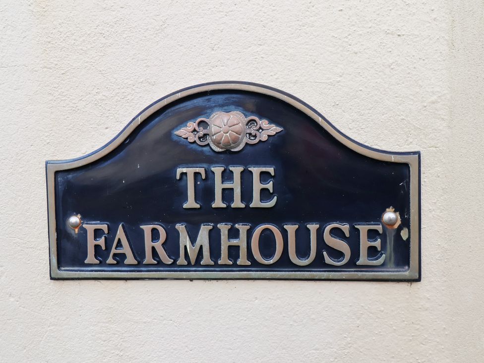 A sign reading The Farmhouse at The Farmhouse in Boggle Hole near Robin Hood's Bay