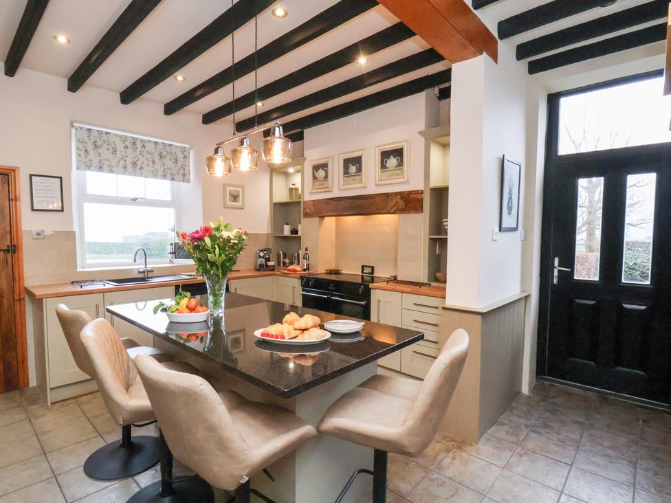 A kitchen with an island and seating at The Farmhouse in Boggle Hole near Robin Hood's Bay