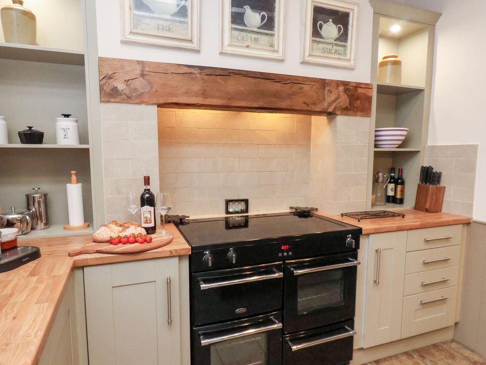 A kitchen with an oven and shelves at The Farmhouse in Boggle Hole near Robin Hood's Bay