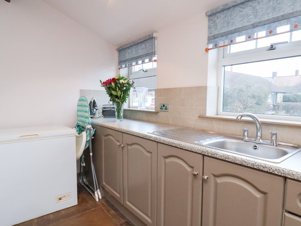 A kitchen with a freezer and sink at The Farmhouse in Boggle Hole near Robin Hood's Bay
