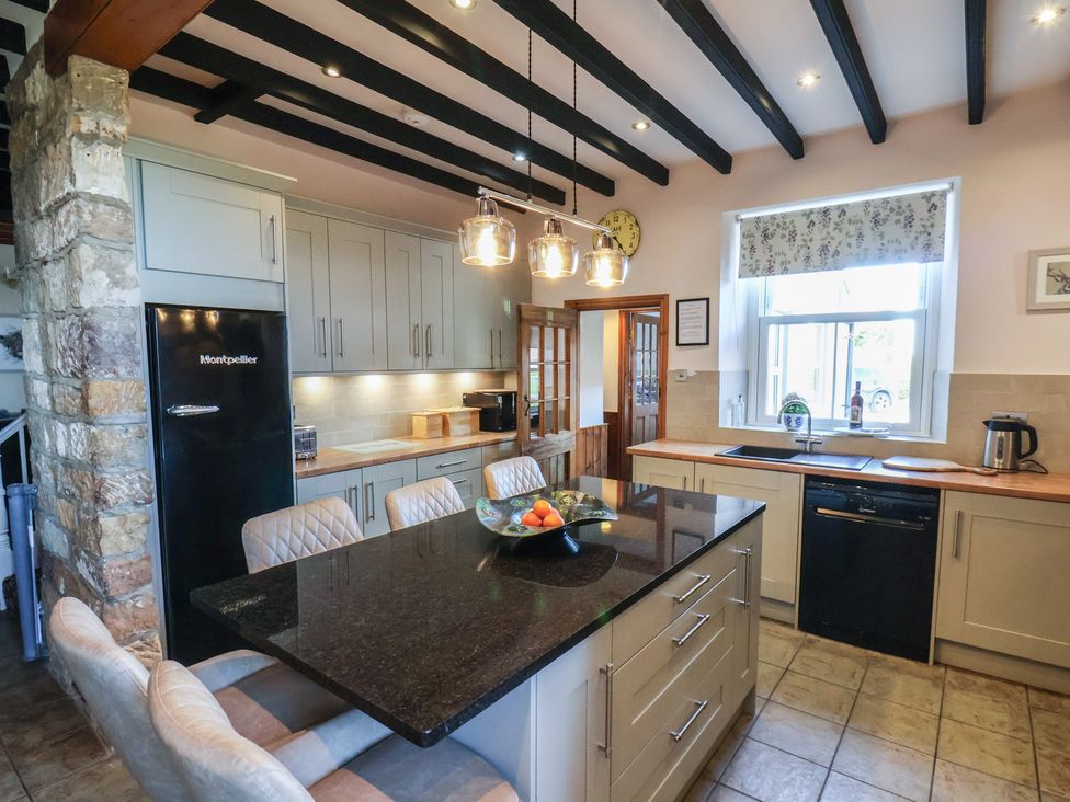 A kitchen with a refrigerator and countertop at The Farmhouse in Boggle Hole near Robin Hood's Bay