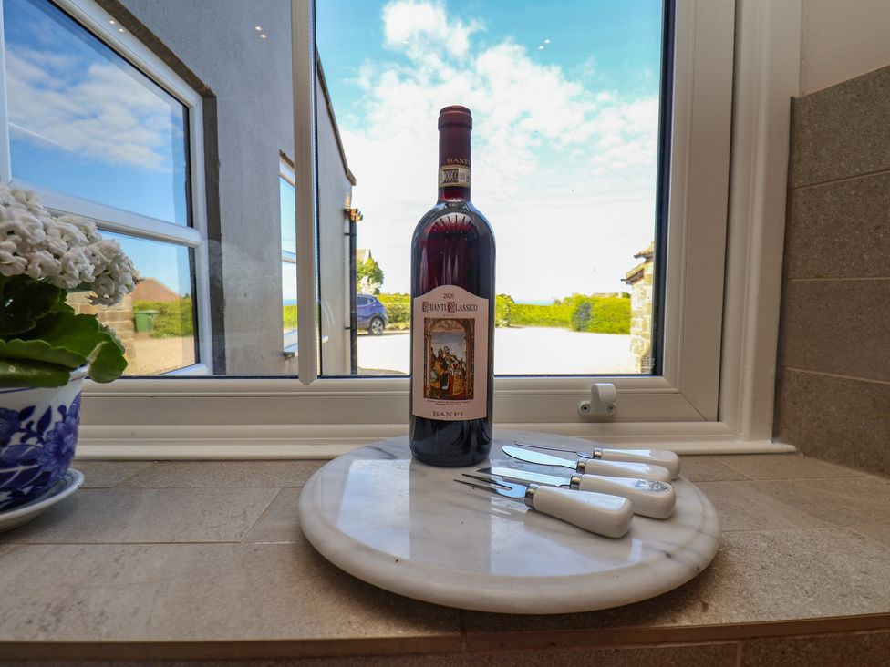 A bottle of wine and cutlery on a marble platter at The Farmhouse Boggle Hole near Robin Hood's Bay