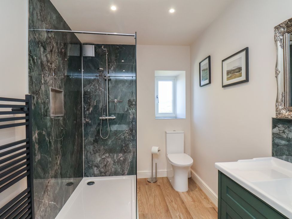 A bathroom featuring a shower, toilet and sink at The Farmhouse in Boggle Hole near Robin Hood's Bay