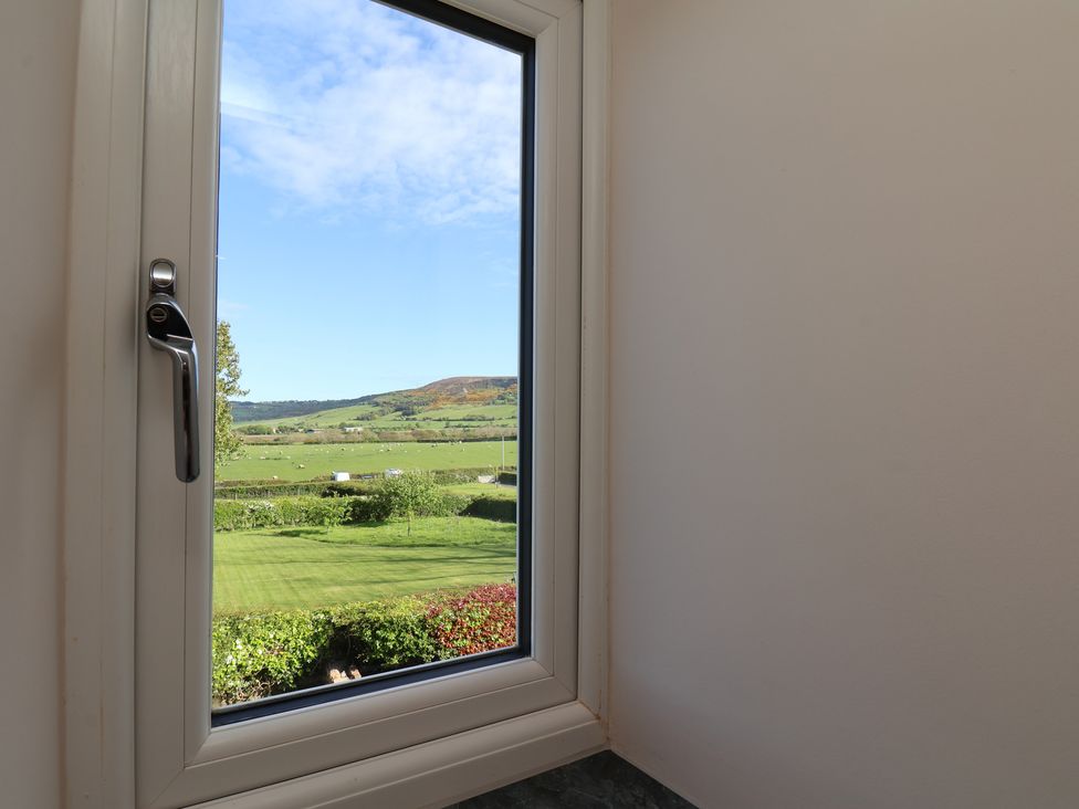 A window overlooking a grassy landscape at The Farmhouse in Boggle Hole near Robin Hood's Bay
