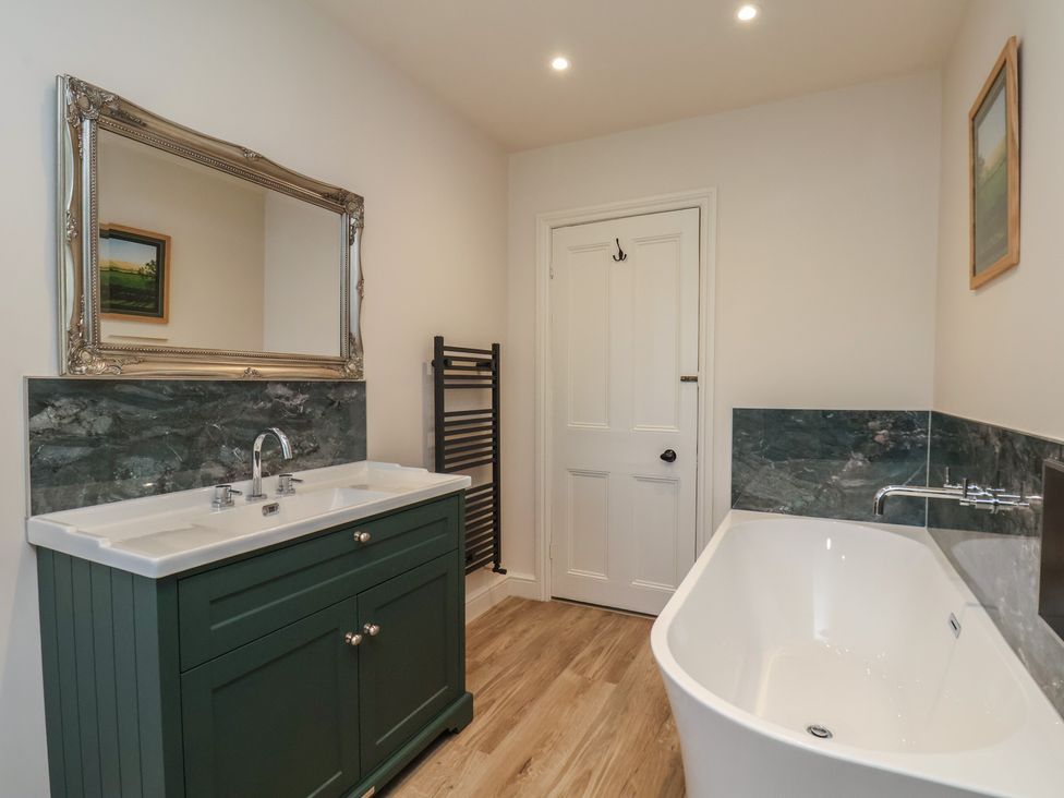 A bathroom with a bathtub and sink at The Farmhouse in Boggle Hole near Robin Hood's Bay