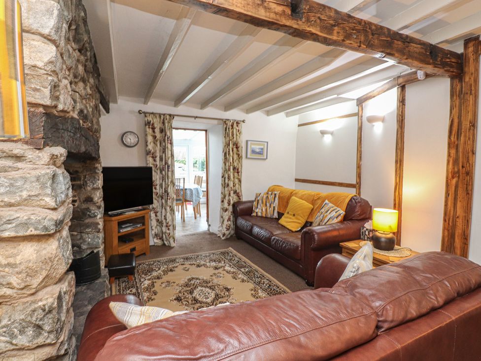 A living room with a tv and sofa at Dolfor in Nefyn