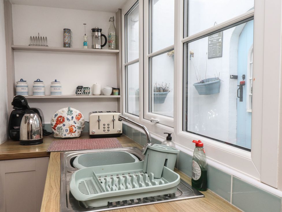 A kitchen with a sink and dish rack at Dolfor in Nefyn