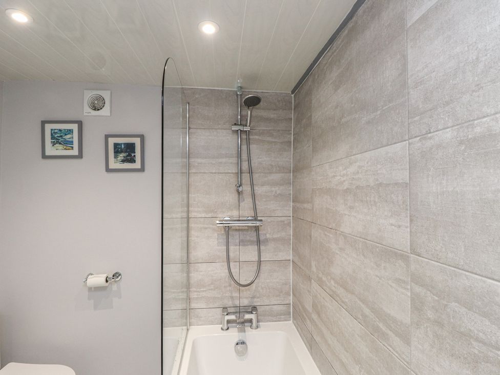 A bathroom with a bathtub and shower fittings at Dolfor in Nefyn