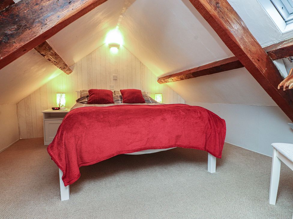 A bedroom with a bed and nightstand at Dolfor in Nefyn