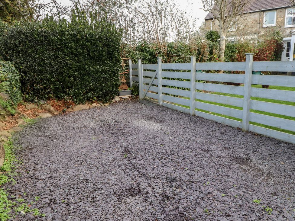 An outdoor space with a gravel surface and a wooden fence at Dolfor in Nefyn