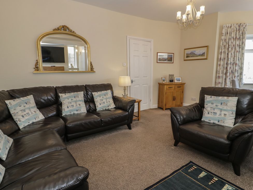 A living room with a sofa and armchair at Roma in Rhos-on-Sea