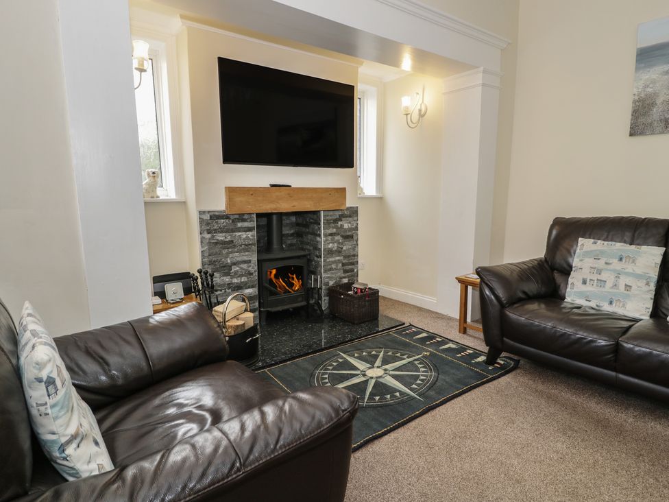 A living room with a fireplace and television at Roma in Rhos-on-Sea