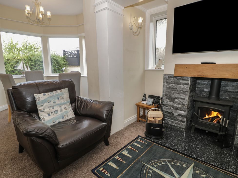 A living room with an armchair and a fireplace at Roma in Rhos-on-Sea