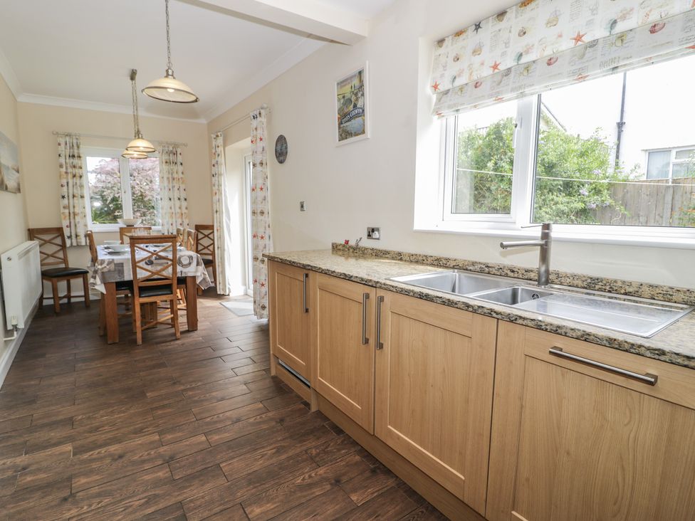 A kitchen with a table and chairs at Roma in Rhos-on-Sea