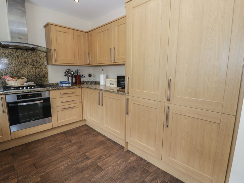 A kitchen with cabinets and appliances at Roma in Rhos-on-Sea