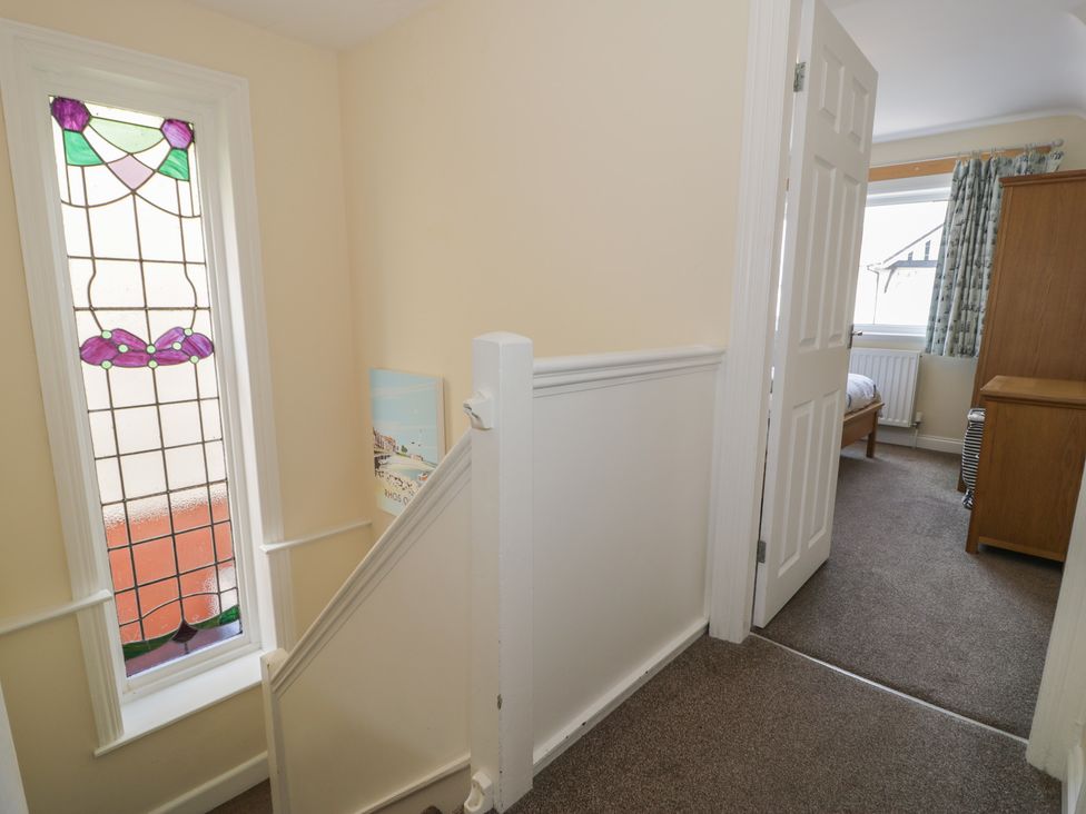 A hallway with a stained glass window at Roma in Rhos-on-Sea