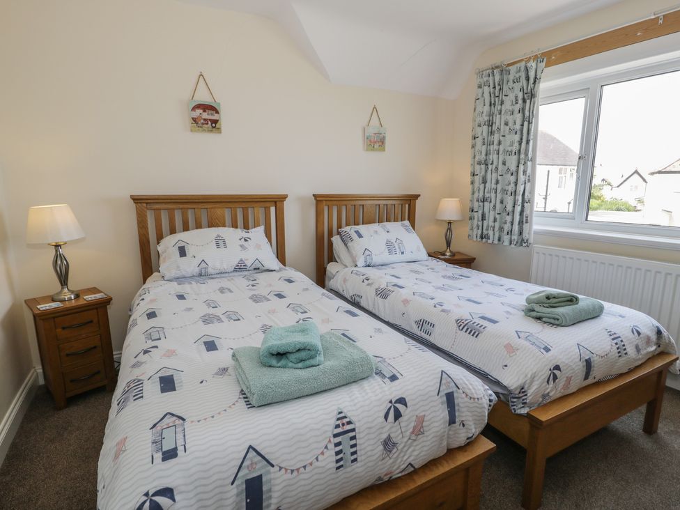 A bedroom with two single beds and a window at Roma in Rhos-on-Sea