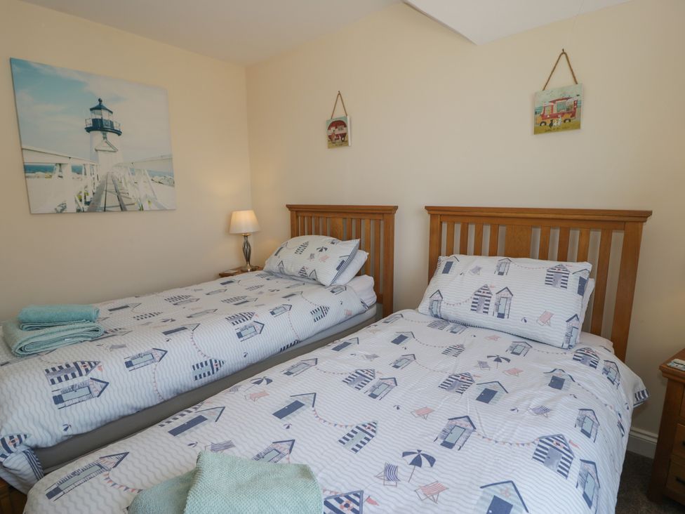 A bedroom with two single beds and a lamp at Roma in Rhos-on-Sea