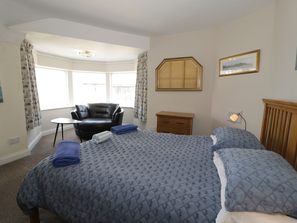 A bedroom with a bed and a chair at Roma in Rhos-on-Sea