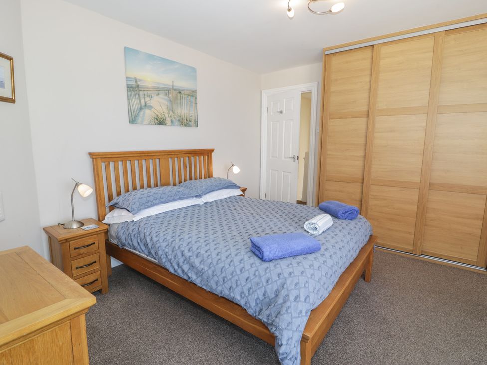 A bedroom with a bed and bedside lamp at Roma in Rhos-on-Sea