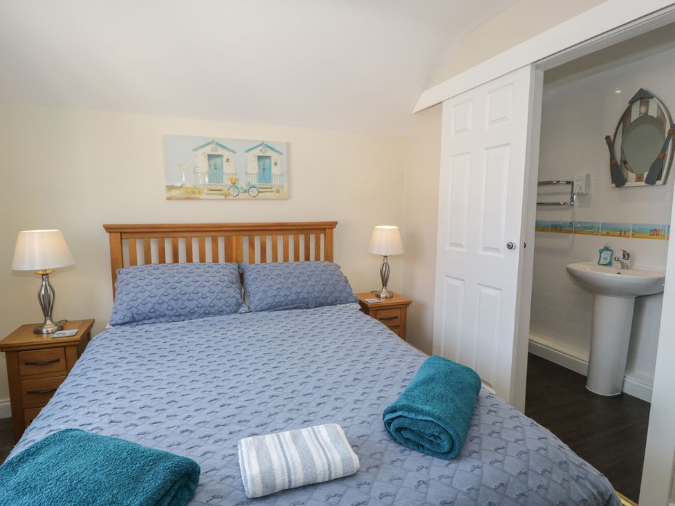 A bedroom with a bed and ensuite bathroom at Roma in Rhos-on-Sea