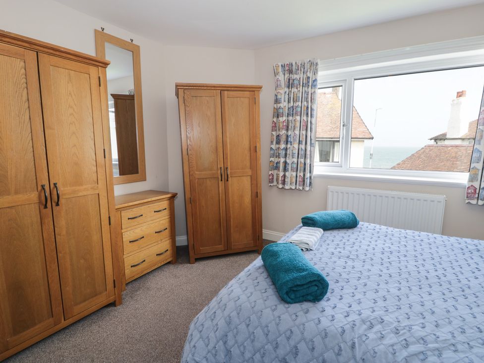 A bedroom with a bed and wooden furniture at Roma in Rhos-on-Sea