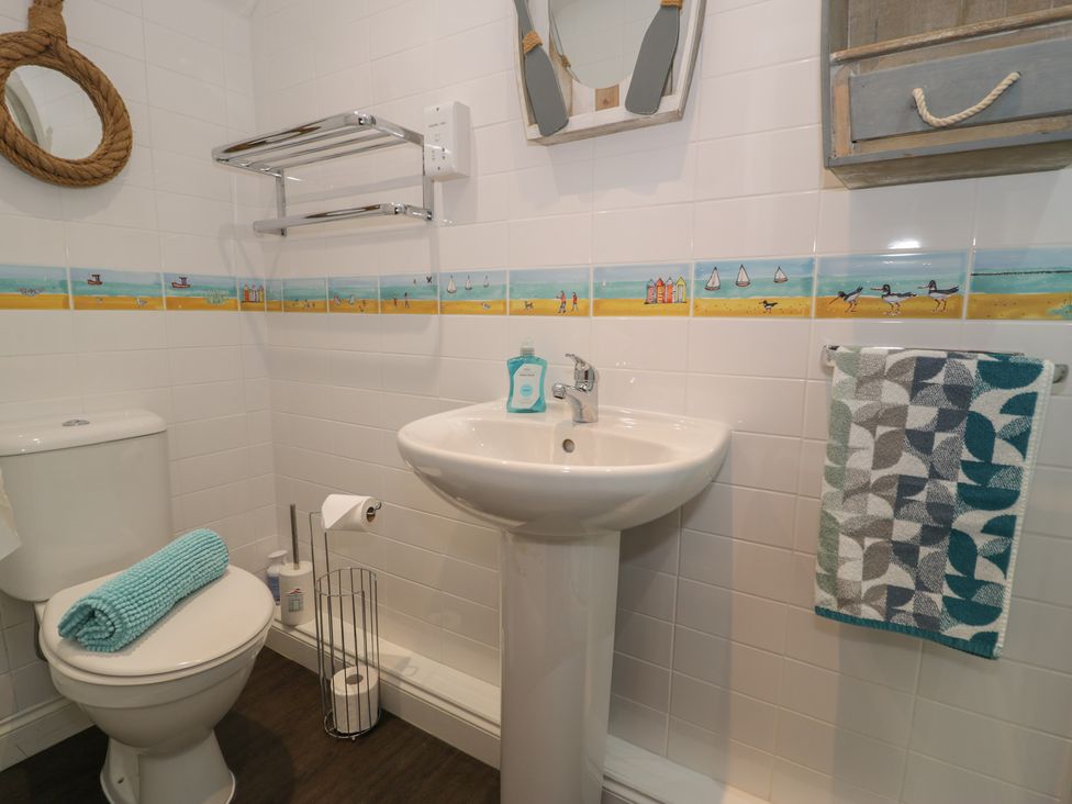 A bathroom with a toilet, sink, and decorative elements at Roma in Rhos-on-Sea