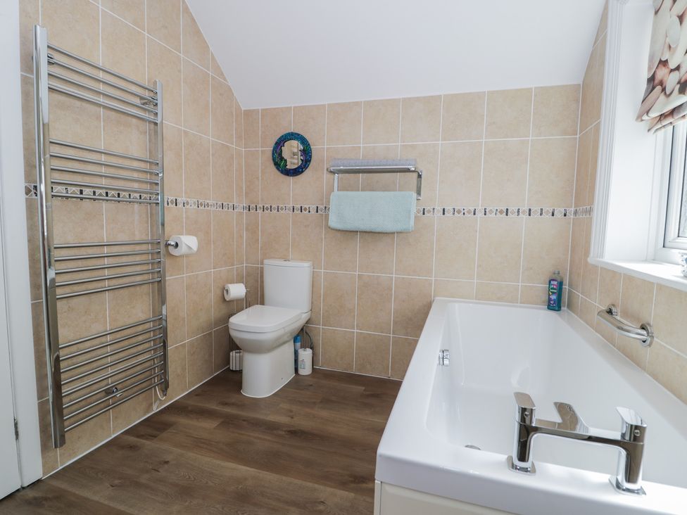 A bathroom with a toilet and bathtub at Roma in Rhos-on-Sea