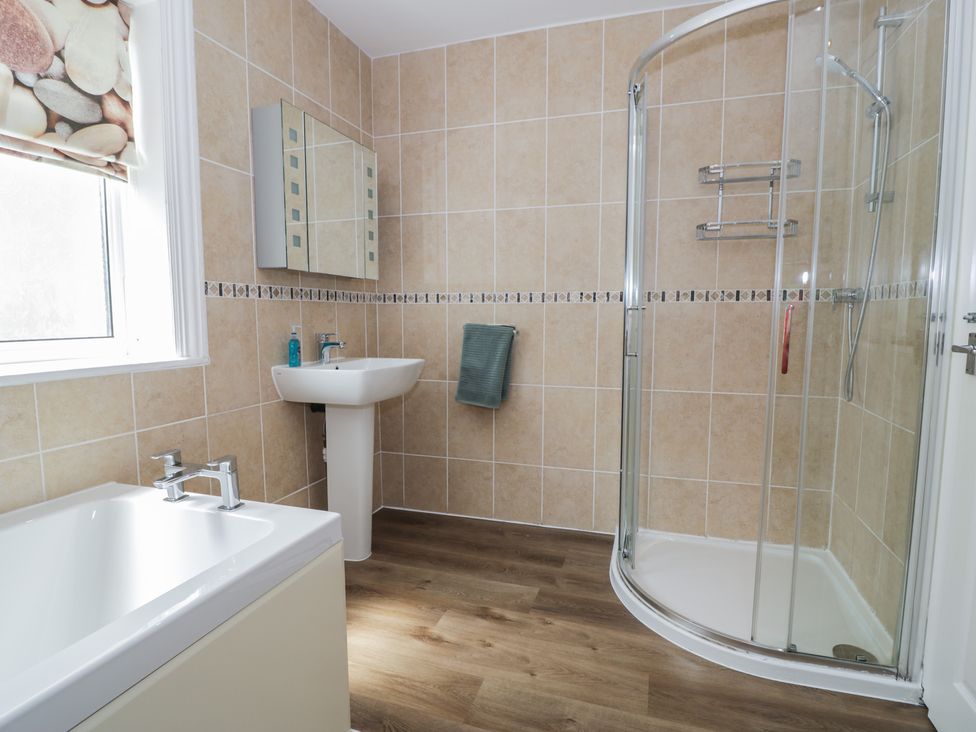 A bathroom with a bathtub and shower at Roma in Rhos-on-Sea