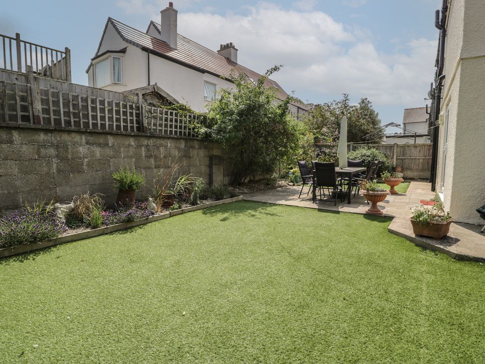 A garden with patio furniture and planters at Roma in Rhos-on-Sea