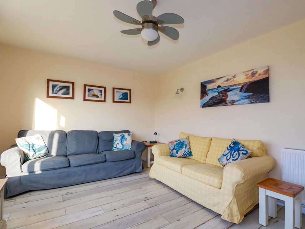 A living room with sofas and artwork at Merlin's Retreat in Tintagel
