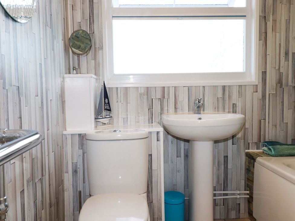A bathroom with a toilet and sink at Merlin's Retreat in Tintagel