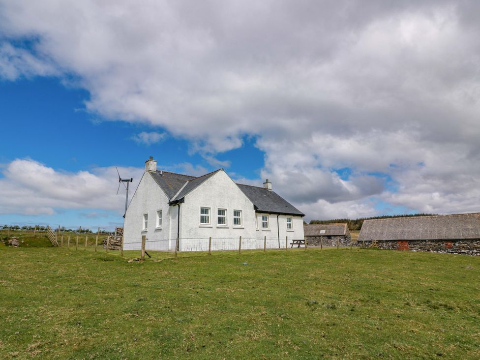 A house with a wind turbine and stone buildings in a grassy area at Little Laight Cairnryan near Stranraer