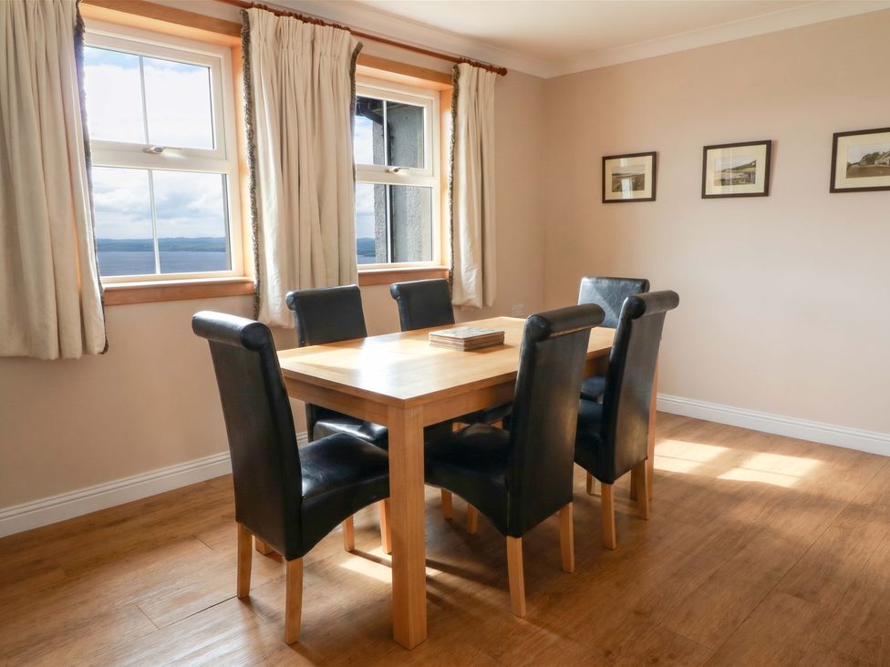 A dining room with a wooden table and black chairs at Little Laight in Cairnryan near Stranraer