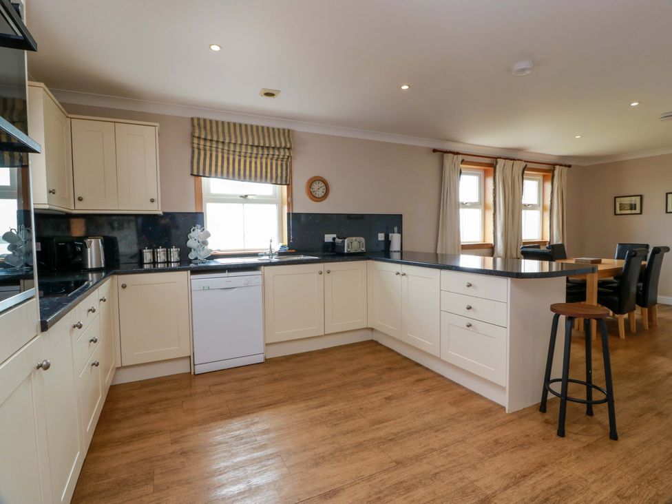A kitchen with cabinets, sink, and dishwasher at Little Laight in Cairnryan near Stranraer