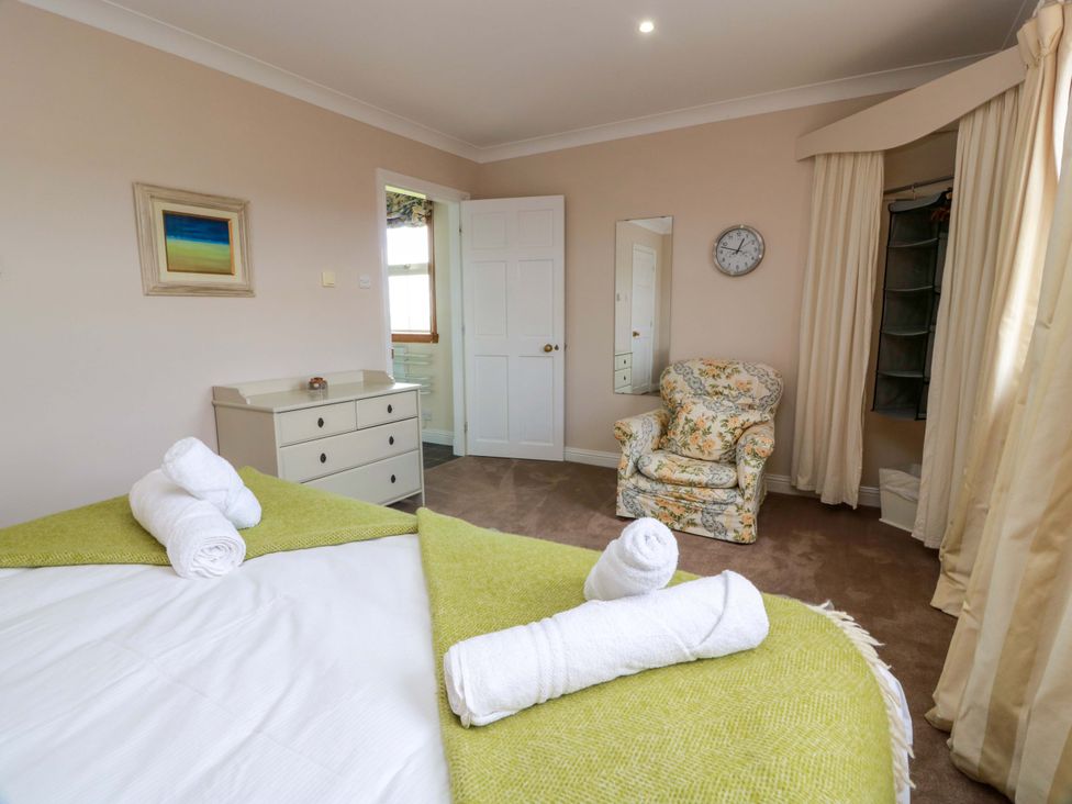 A bedroom with a bed and chair at Little Laight in Cairnryan near Stranraer