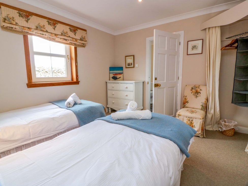 A bedroom with twin beds and a dresser at Little Laight in Cairnryan near Stranraer